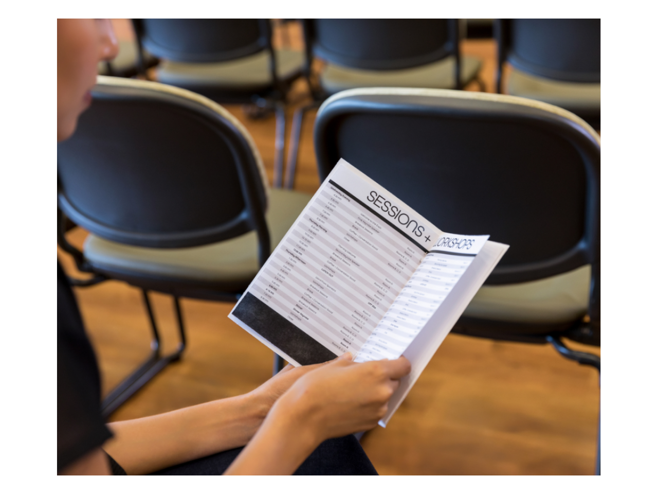 Stock image of forum participant holding a program of sessions