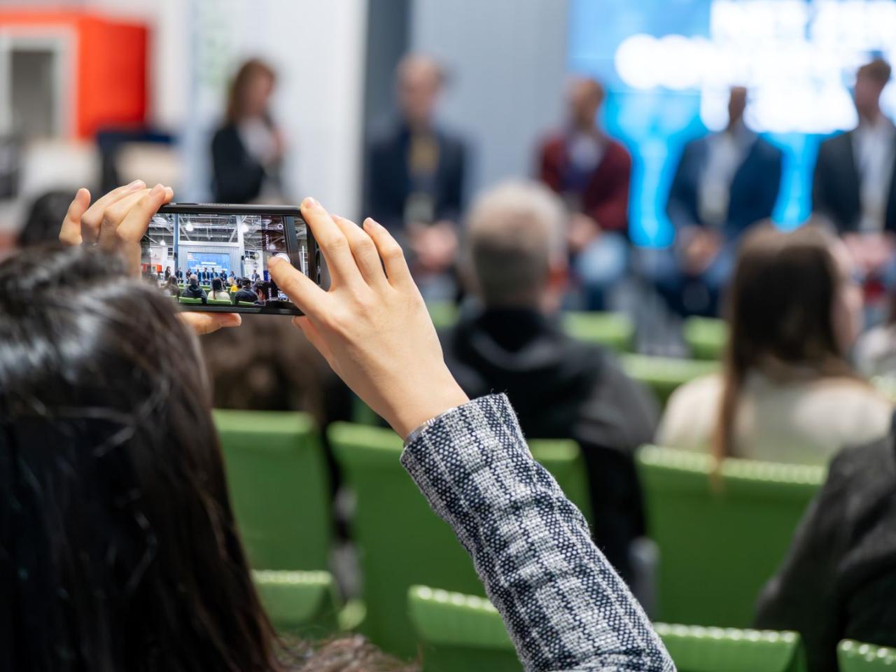 Delegate takes a photo of a conference panel